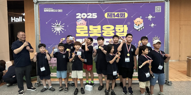 지난달 대전컨벤션센터에서 열린 ‘로봇 융합 페스티벌’의‘자율주행자동차(알티노) AI 미션 챌린지’에 참가한 진천지역 초등생 12명이 수상 메달을 목에 걸고 기념사진을 찍고 있다. 진천군 제공