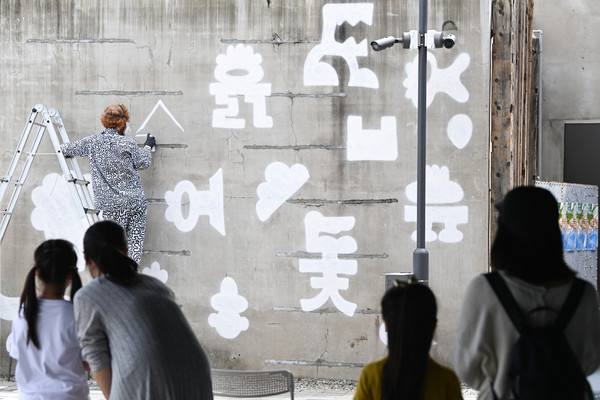 1일 세종시 조치원 1927 아트센터 일원에서 열린 '2025 한글 국제 프레 비엔날레' 전시를 찾은 시민들이 영국의 세계적인 예술가 미스터 두들의 라이브 드로잉을 관람하고 있다. '2025 한글 국제 프레 비엔날레' 전시는 오는 10월 12일까지 이어진다. 김주형 기자 kjh2667_@cctoday.co.kr