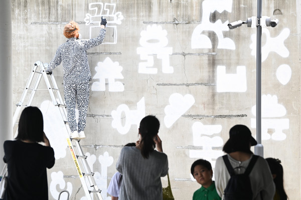 1일 세종시 조치원 1927 아트센터 일원에서 열린 '2025 한글 국제 프레 비엔날레' 전시를 찾은 시민들이 영국의 세계적인 예술가 미스터 두들의 라이브 드로잉을 관람하고 있다. '2025 한글 국제 프레 비엔날레' 전시는 오는 10월 12일까지 이어진다. 김주형 기자 kjh2667_@cctoday.co.kr