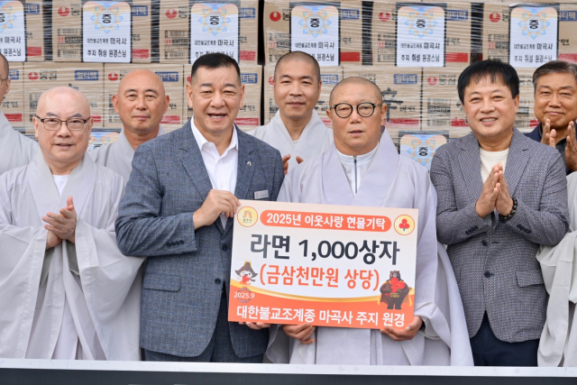 마곡사 주지 원경 스님과 최원철 공주시장 이윤진 마곡사 신도회장(오른쪽)이 라면 전달식을 하고 있다.사진=김익환 기자