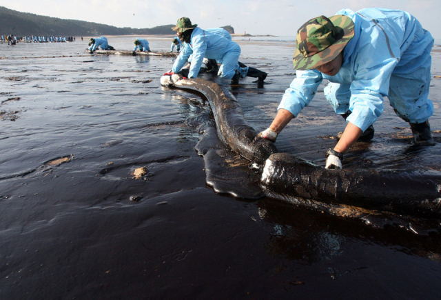 태안 기름유출 피해를 받은 만리포 해수욕장에서 민관군이 방제작업을 하는 모습. 2007년 12월 7일 충남 태안군 앞바다에서 홍콩 선적의 유조선 ‘허베이 스피릿 호’와 삼성물산 소속의 ‘삼성 1호’가 충돌하면서 유조선 탱크에 있던 총 1만2547킬로리터(7만8918 배럴)의 원유가 태안 인근 해역으로 유출됐다. 충청투데이DB