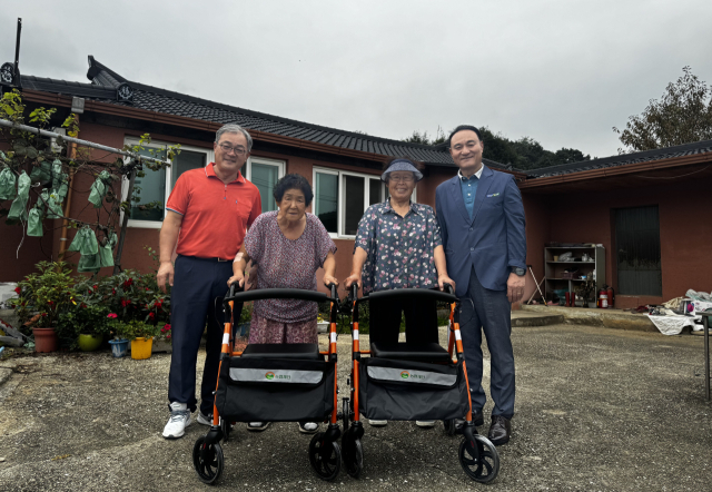 박근수(오른쪽) 조합장이 보행보조기를 전달하고 있다.제천농협 제공