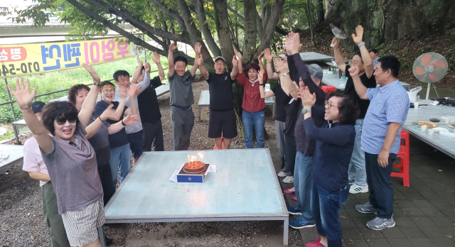 오송초 49회 동기생들이 케이크에 촛불을 밝히고 서로의 건강과 우정을 소망하며 만세를 부르고 있다. 사진=김진식 기자