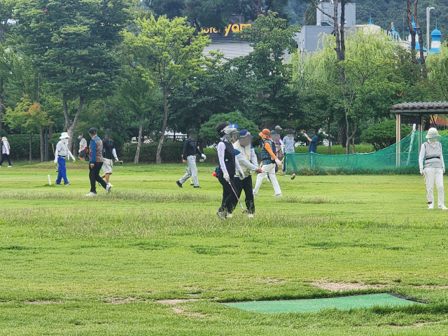 어르신들이 천안 도솔공원 잔디광장에서 파크골프를 즐기고 있다. 사진=박동혁 기자.
