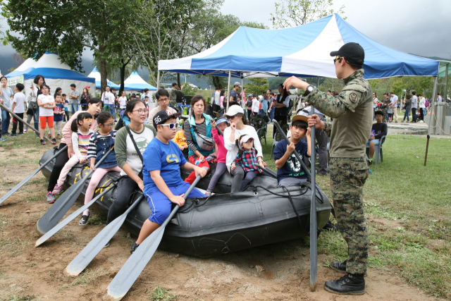 ▲병영체험장을 찾은 관람객들이 고무보트를 타고 도하 체험을 하며 군사훈련의 긴장감과 박진감을 생생히 느끼고 있다.