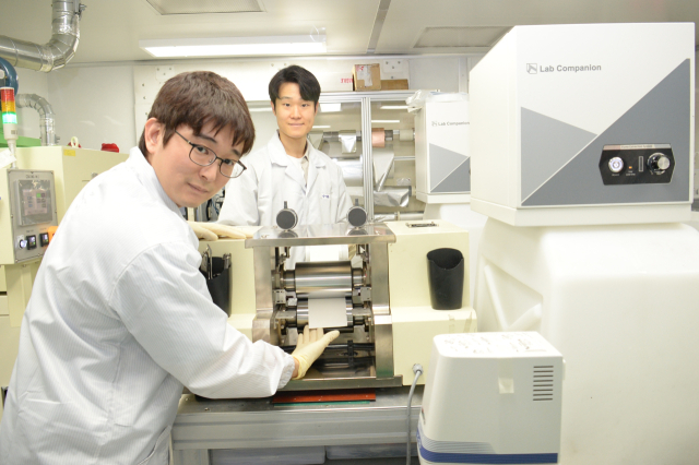 ETRI 연구진이 고체전해질막의 롤투롤 공정을 검토하는 모습.ETRI 제공.