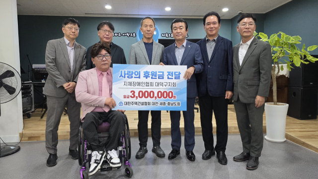 김용관 대한주택건설협회 대전·세종·충남도회장을 비롯한 협회 임직원과 박찬진 대전시지체장애인협회 대덕구지회장이 22일 성금 전달식을 가진 뒤 기념촬영을 하고 있다. 협회 제공