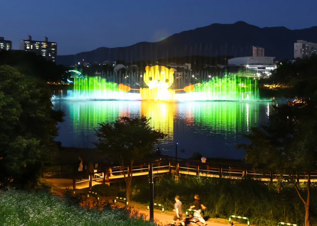 다채로운 음악과 어우러져 화려한 물줄기를 뿜어내는 충주 호암지 음악분수 공연 모습.