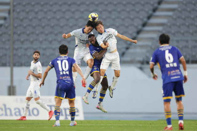 27일 오후 이순신종합운동장에서 치러진 ‘하나은행 K리그2 2025’ 31라운드 아산과 수원삼성블루윙즈의 경기는 원정팀 수원의 3대 1 승리로 마무리됐다. 아산 은고이(가운데)가 수원 선수들과 공중볼 경합을 하고 있다. 한국프로축구연맹 제공.