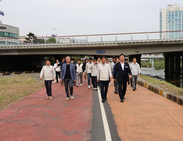 김제선 대전 중구청장과 윤태연 대한전문건설협회 대전시회장, 협회 회원사 대표 등이 21일 대전 천변에서 ‘주민과 함께하는 기분 좋은 동행’ 행사를 진행하고 있다. 대전시회 제공