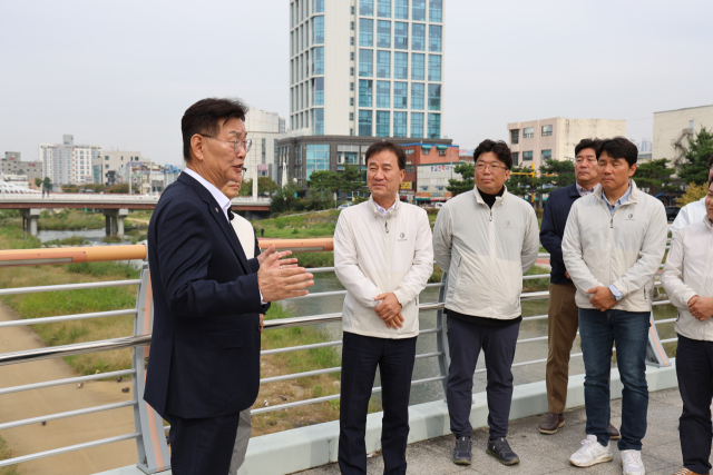 김제선 대전 중구청장과 윤태연 대한전문건설협회 대전시회장, 협회 회원사 대표 등이 21일 대전 천변에서 ‘주민과 함께하는 기분 좋은 동행’ 행사를 진행하고 있다. 대전시회 제공
