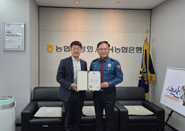 ▲유동하 논산경찰서장으로부터 감사장을 받은 농협은행 논산시지부 직원이 함께 기념촬영을 하고 있는 모습.