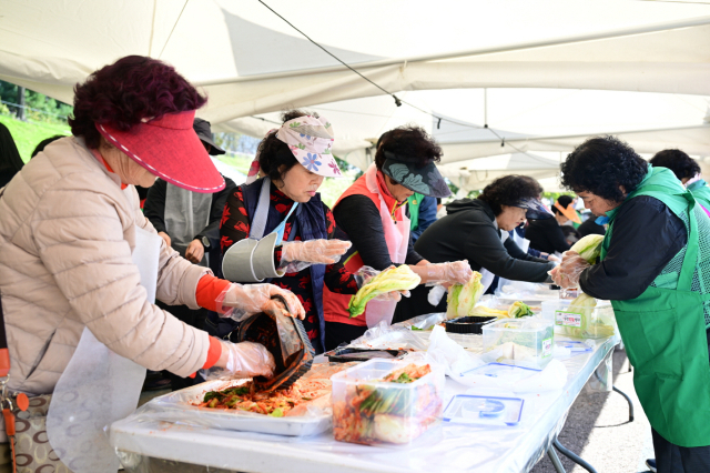 ▲관광객들이 고무장갑을 끼고 웃음 가득한 얼굴로 김치를 담그며 즐거운 체험을 하고 있는 ‘강경젓갈 김치담그기 체험’ 현장 모습.