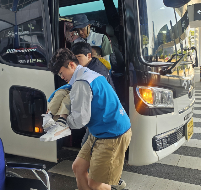 신서천건설본부 직원이 제주도 여행에서 버스 하차를 돕고 있는 모습.사진=신서천건설본부 제공.