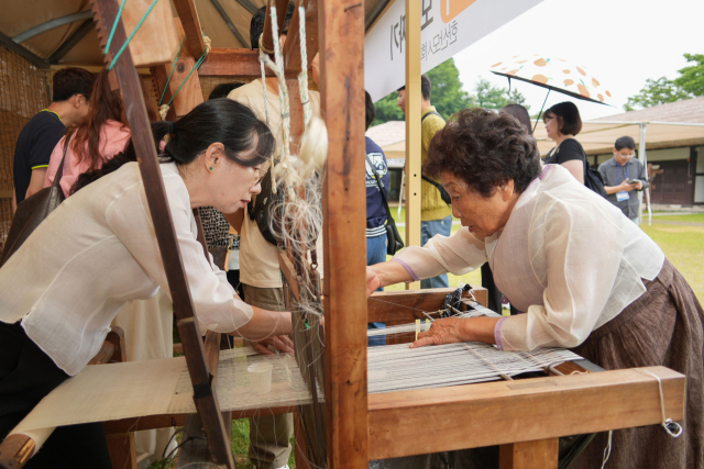 한산모시공예마을에서 모시짜기 체험을 하고 있는 관광객.사진=서천군 제공.