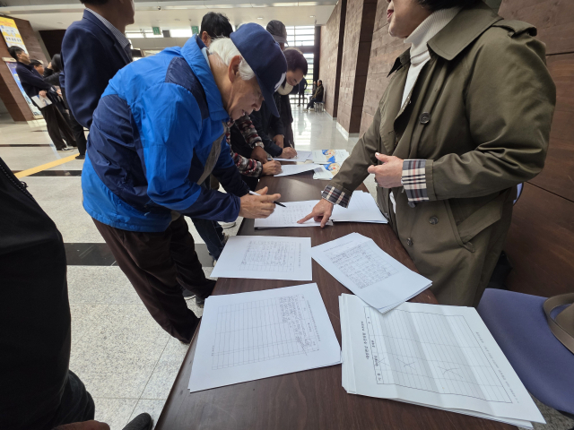 대전시-금산군 통합 공청회 시작전에 통합에 찬성하는 서명을 받고 있다. 사진=이상문 기자
