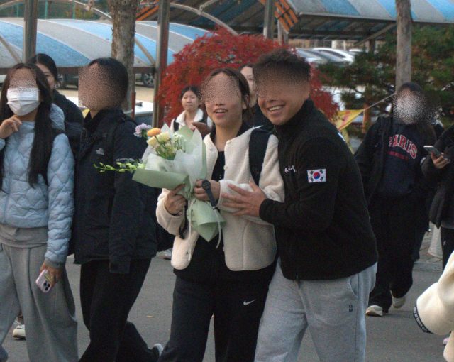 2026학년도 대학수학능력시험이 치러진 13일 오후 청주시 흥덕구 봉명동 봉명고등학교에서 학부모가 시험을 마친 수험생에게 꽃다발을 전달하고 있다. 사진=강준식 기자