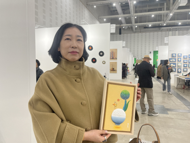 14일 대전 중구 선화동에서 K-아트페어(이하 디카프) 관람을 온 허애란 씨(58)는 예인갤러리의 ‘고봉밥’ 작품을 구매했다. 사진=조정민 기자